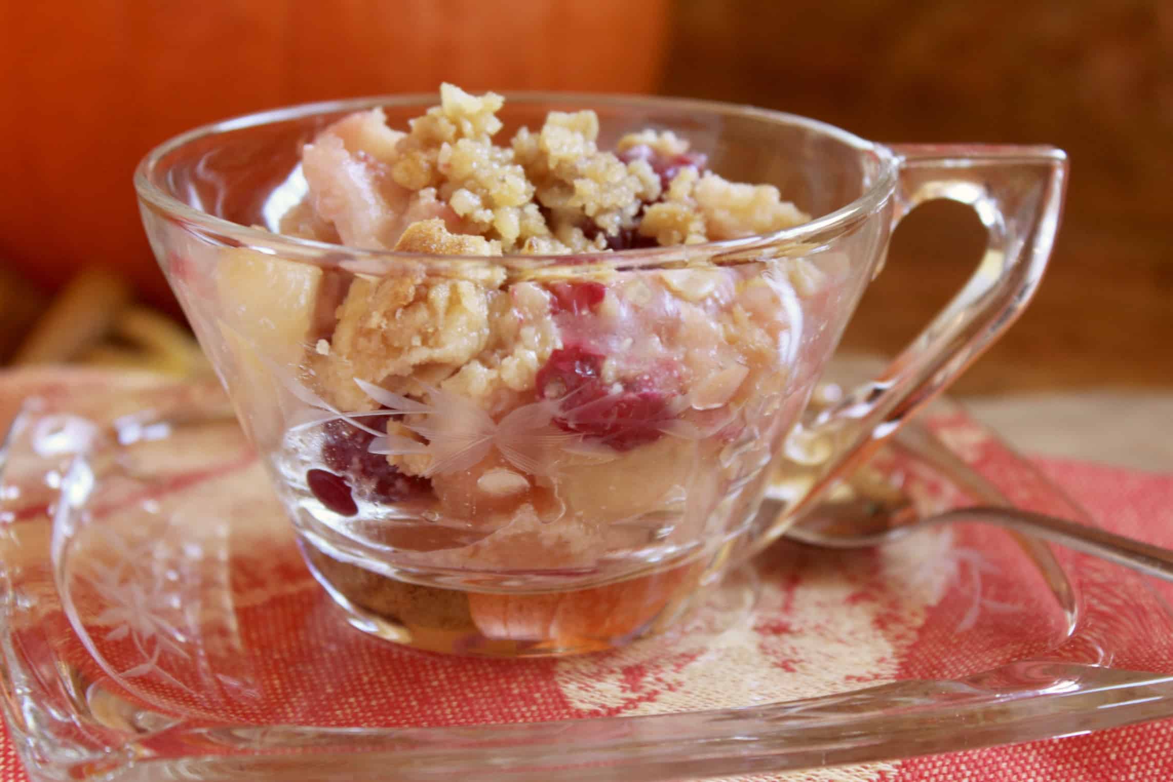 apple cranberry crisp in glass cup and saucer