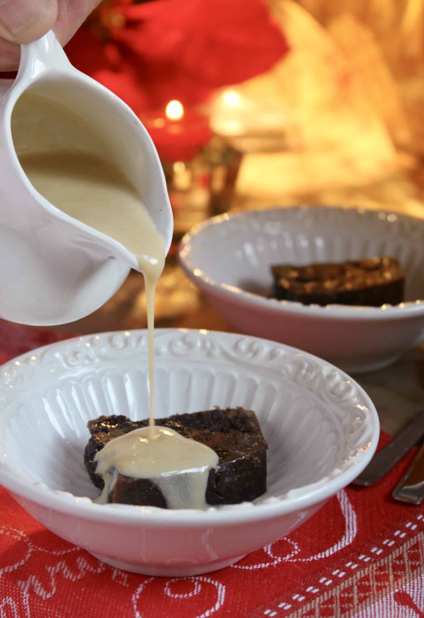 pouring brandy sauce on Christmas pudding in bowl