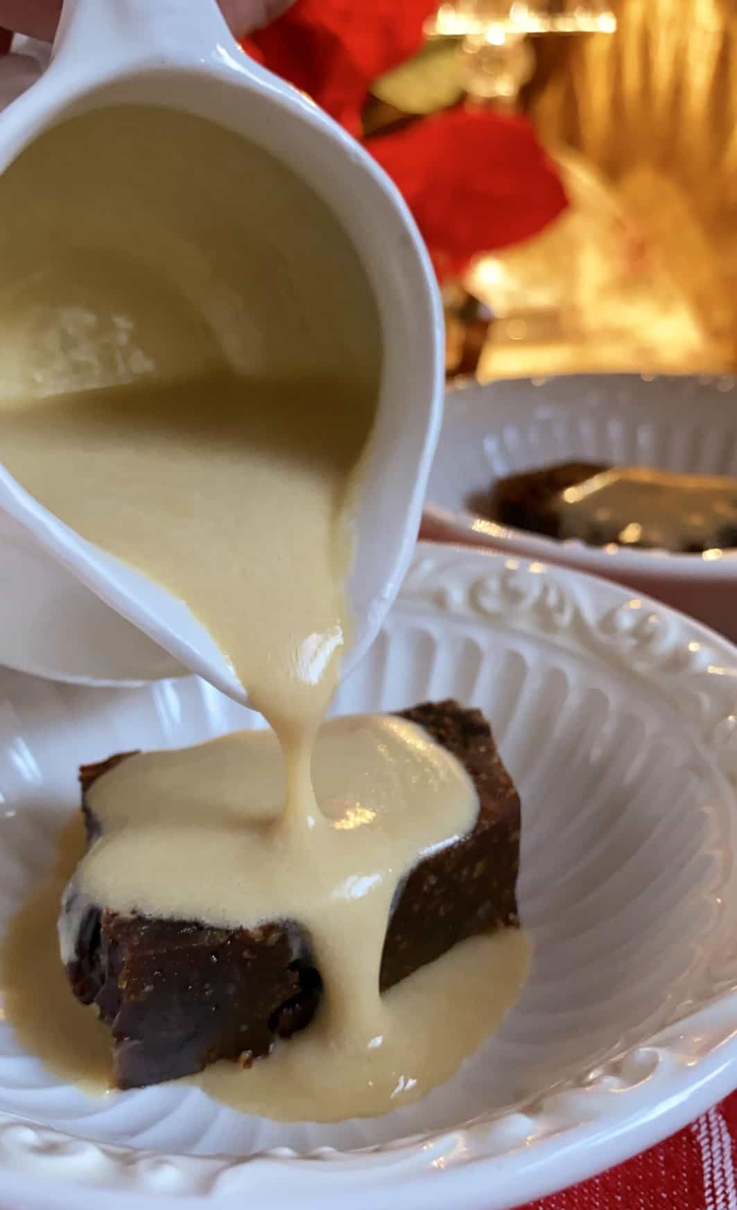 pouring brandy sauce on Christmas pudding in bowl