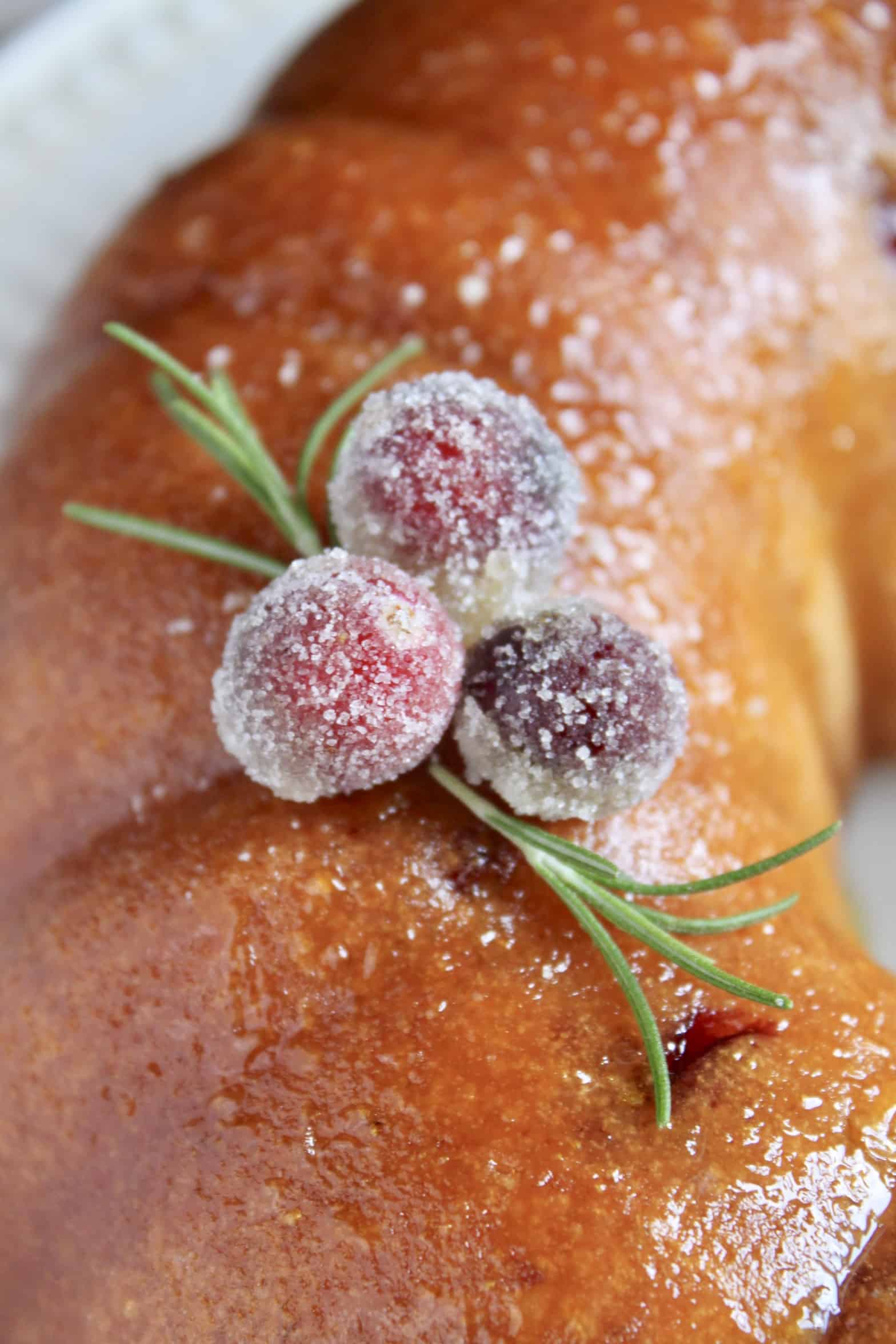 sugared cranberries and rosemary atop a cake