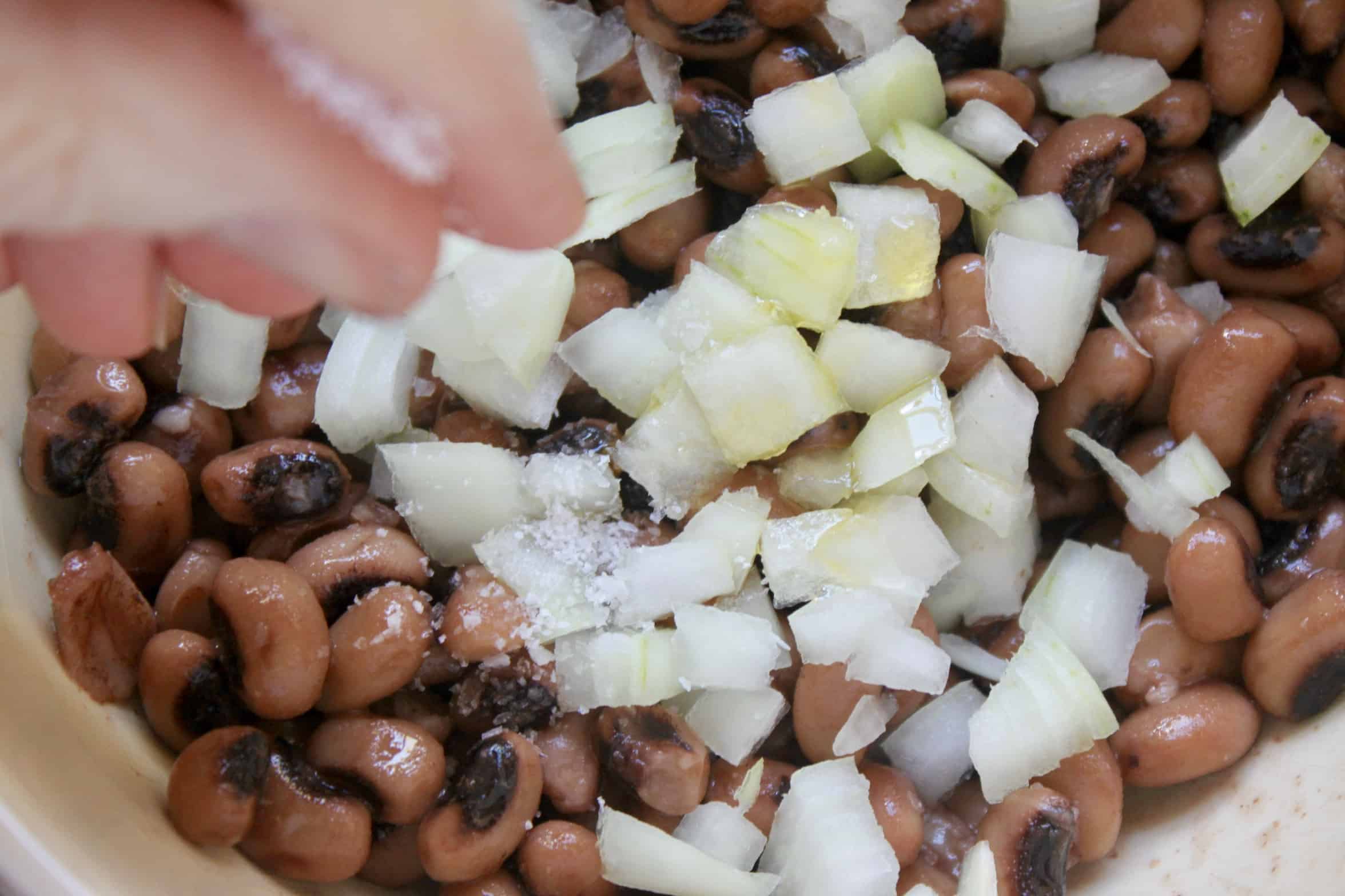 adding salt to onion and peas