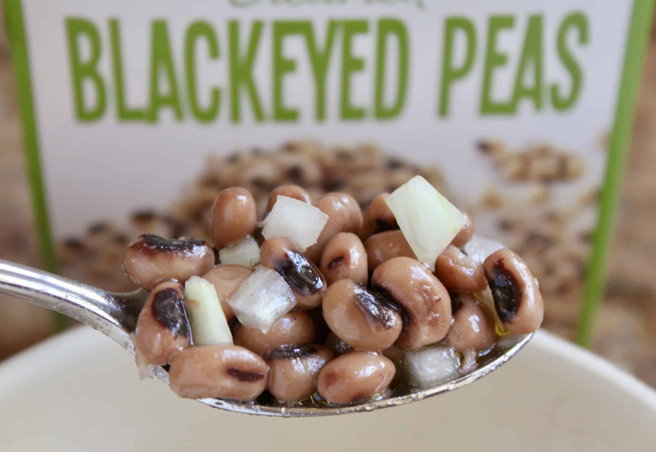 black eyed peas in a spoon with text 