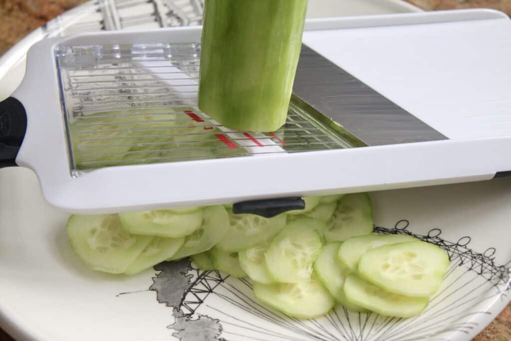 slicing cucumber in a mandoline