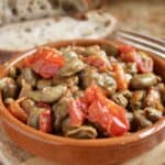 fava beans and tomatoes in a bowl with bread