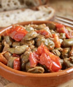 fava beans and tomatoes in a bowl with bread