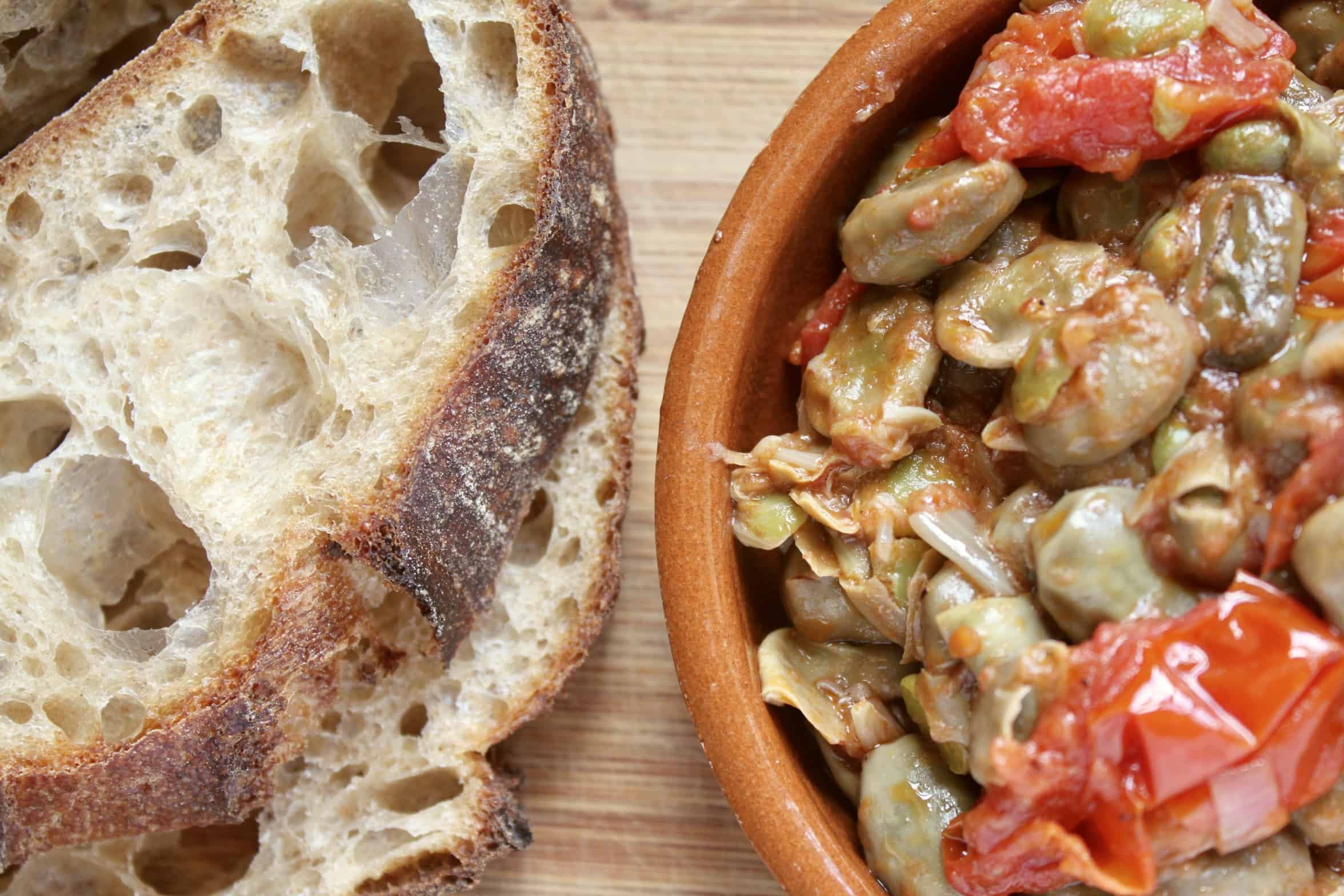 flatlay broad beans in a bowl with bread