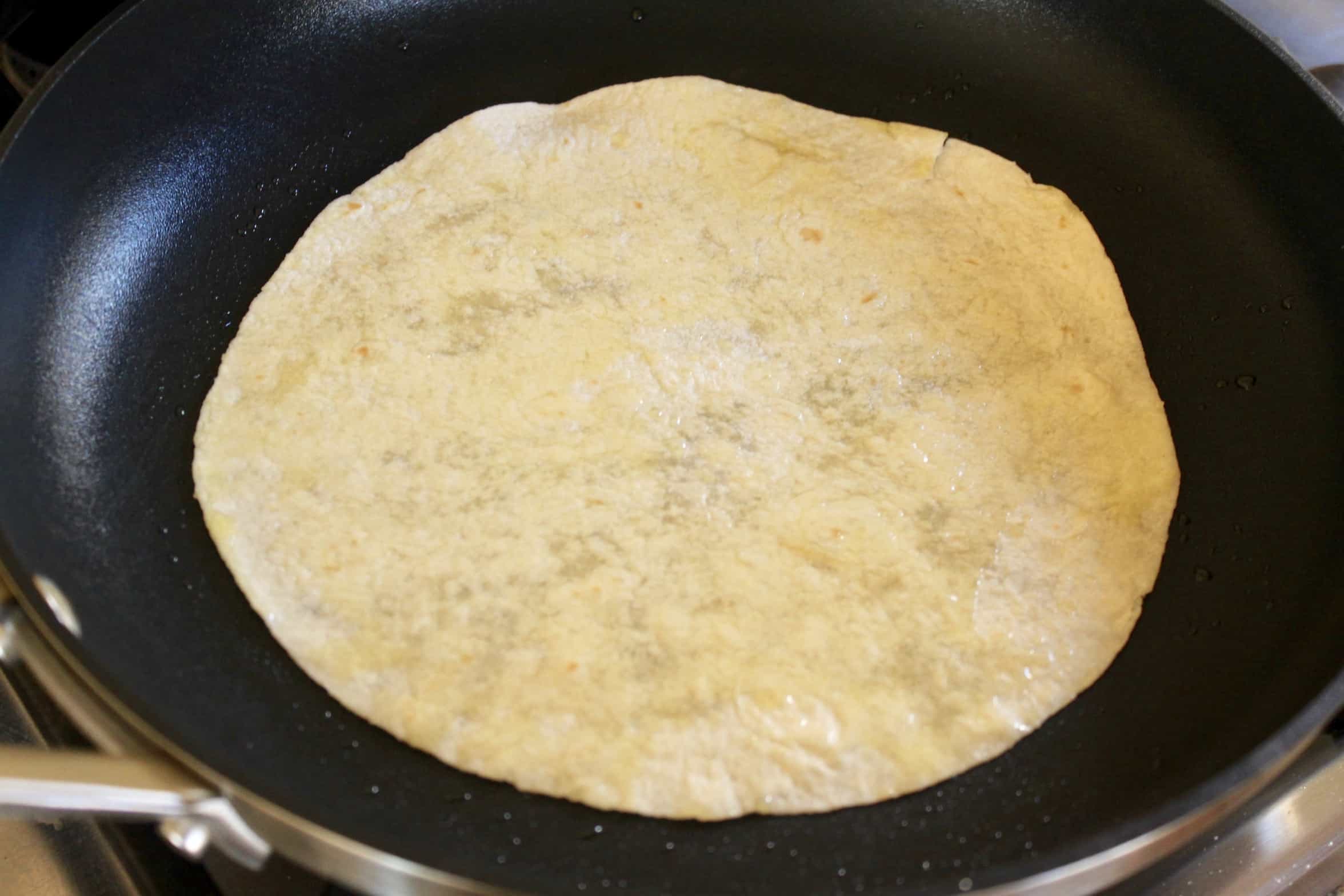 quickly heating the tortilla in oil