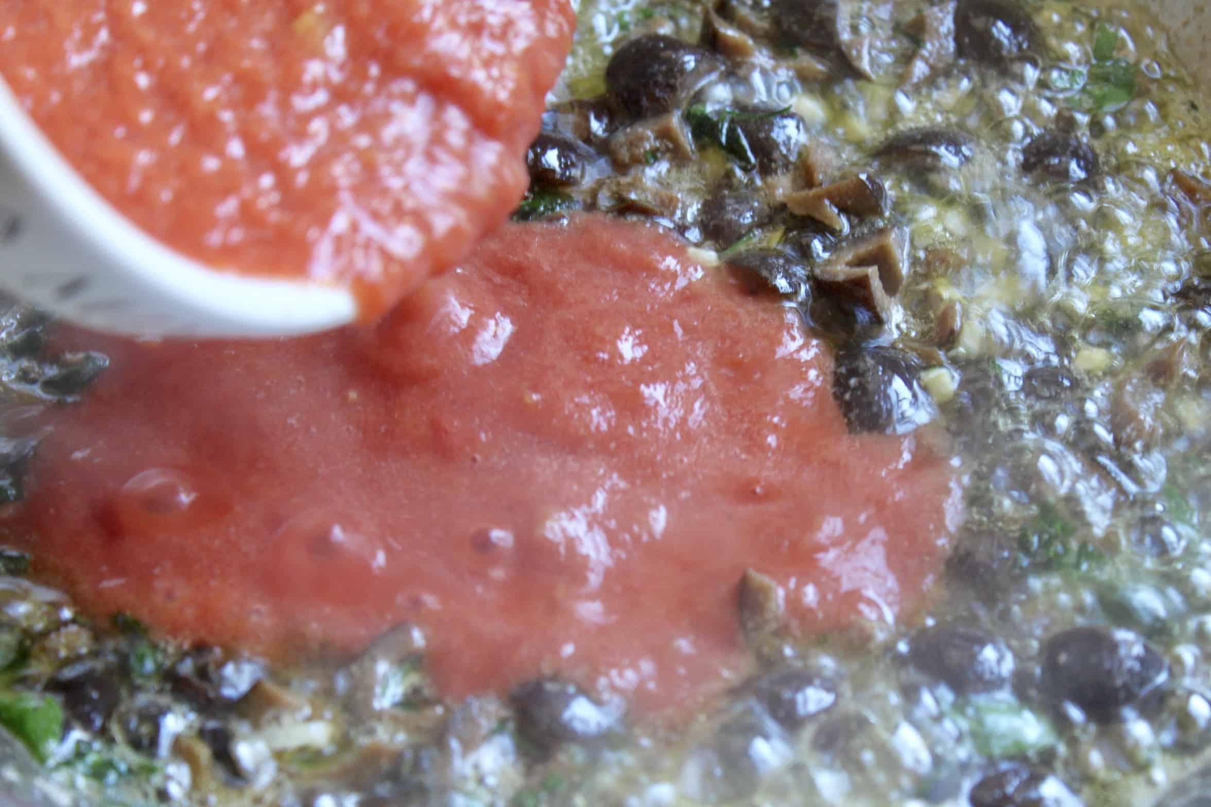 adding tomatoes to the sauce