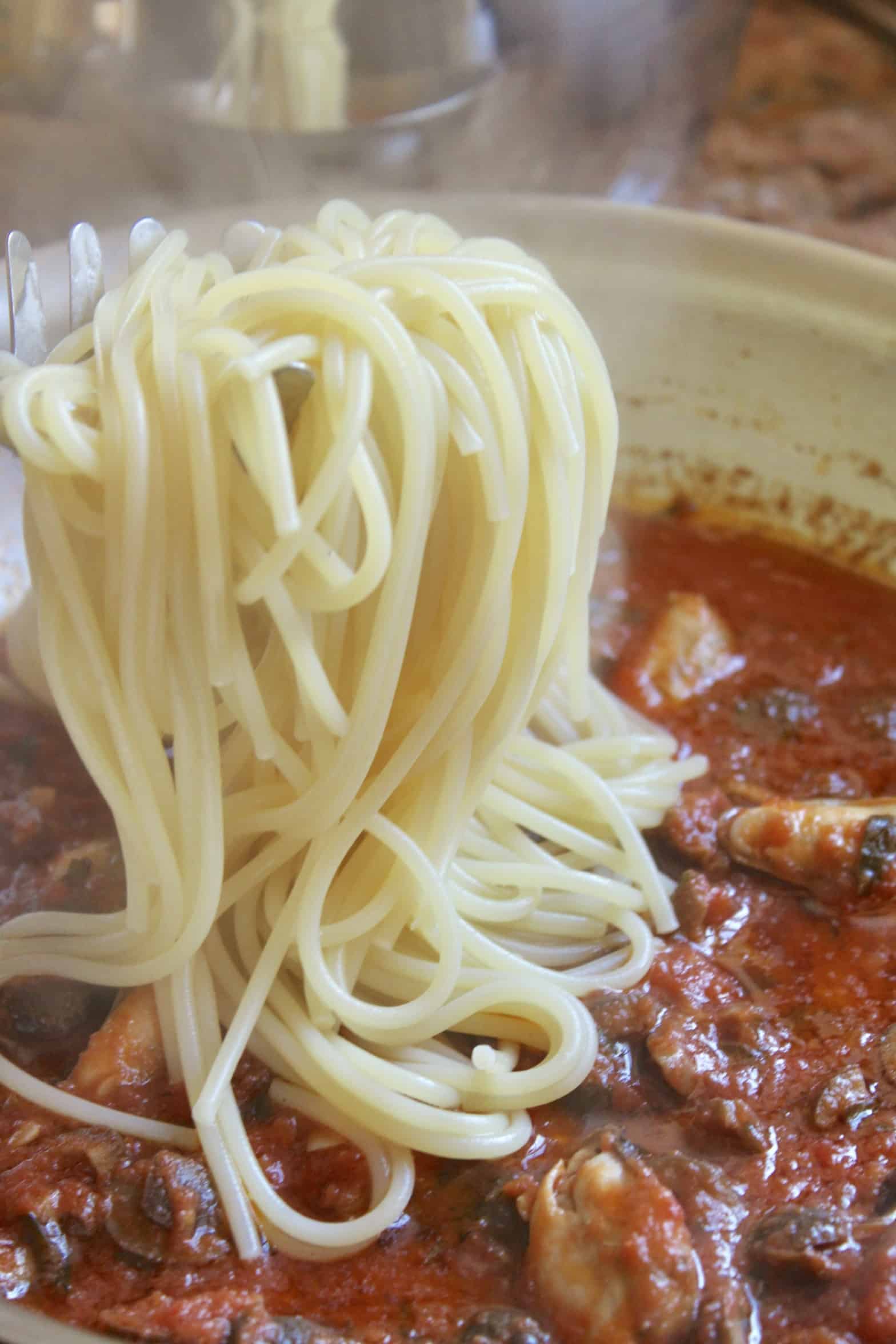 adding spaghetti to the sauce