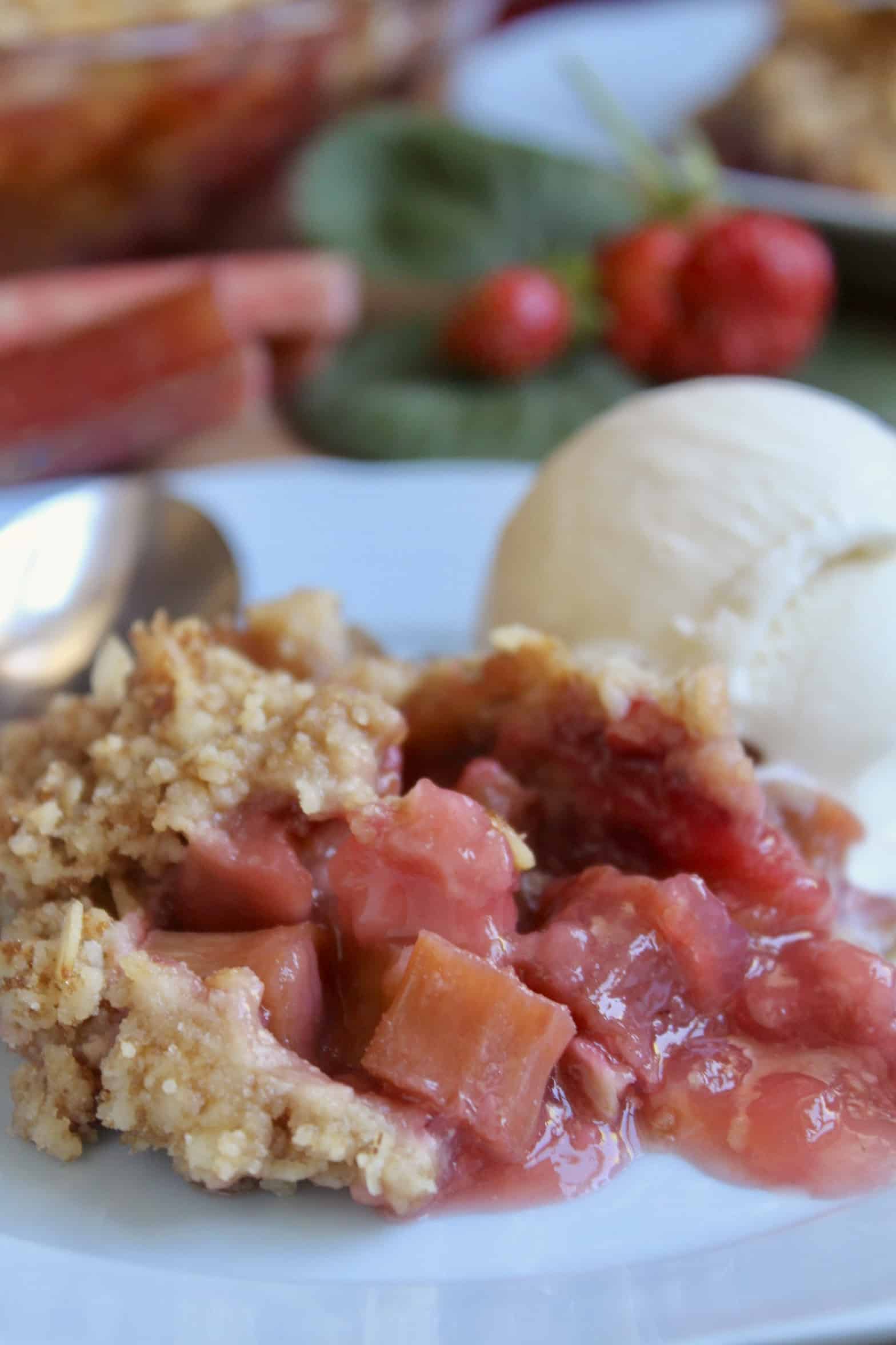 strawberry rhubarb crisp with ice cream on a blue plate