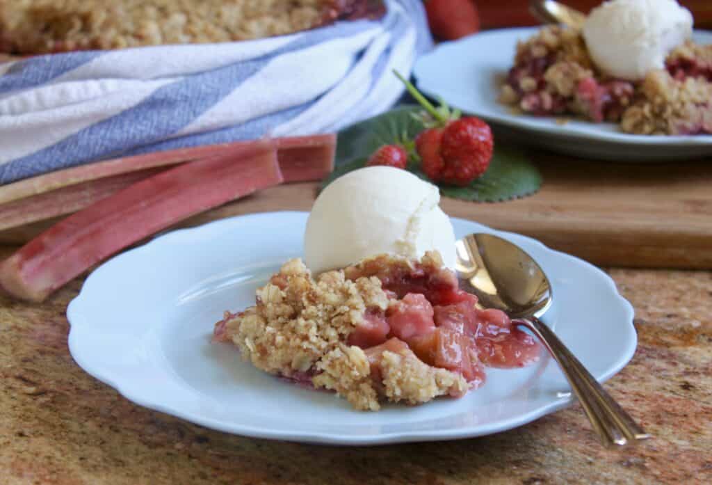 strawberry rhubarb crisp with ice cream on a blue plate