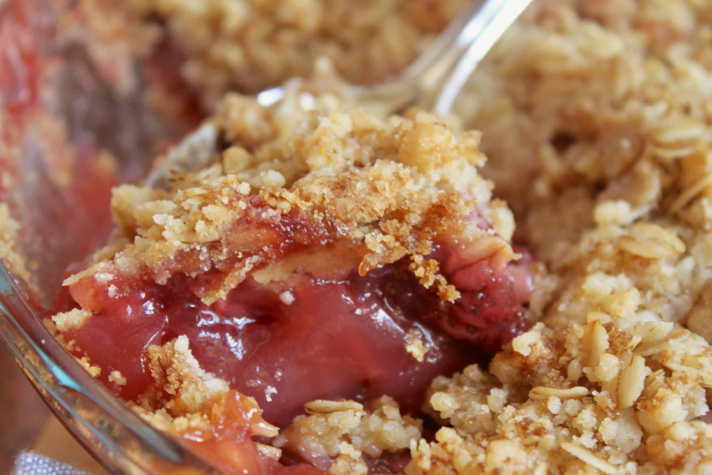 serving strawberry rhubarb crisp with a spoon