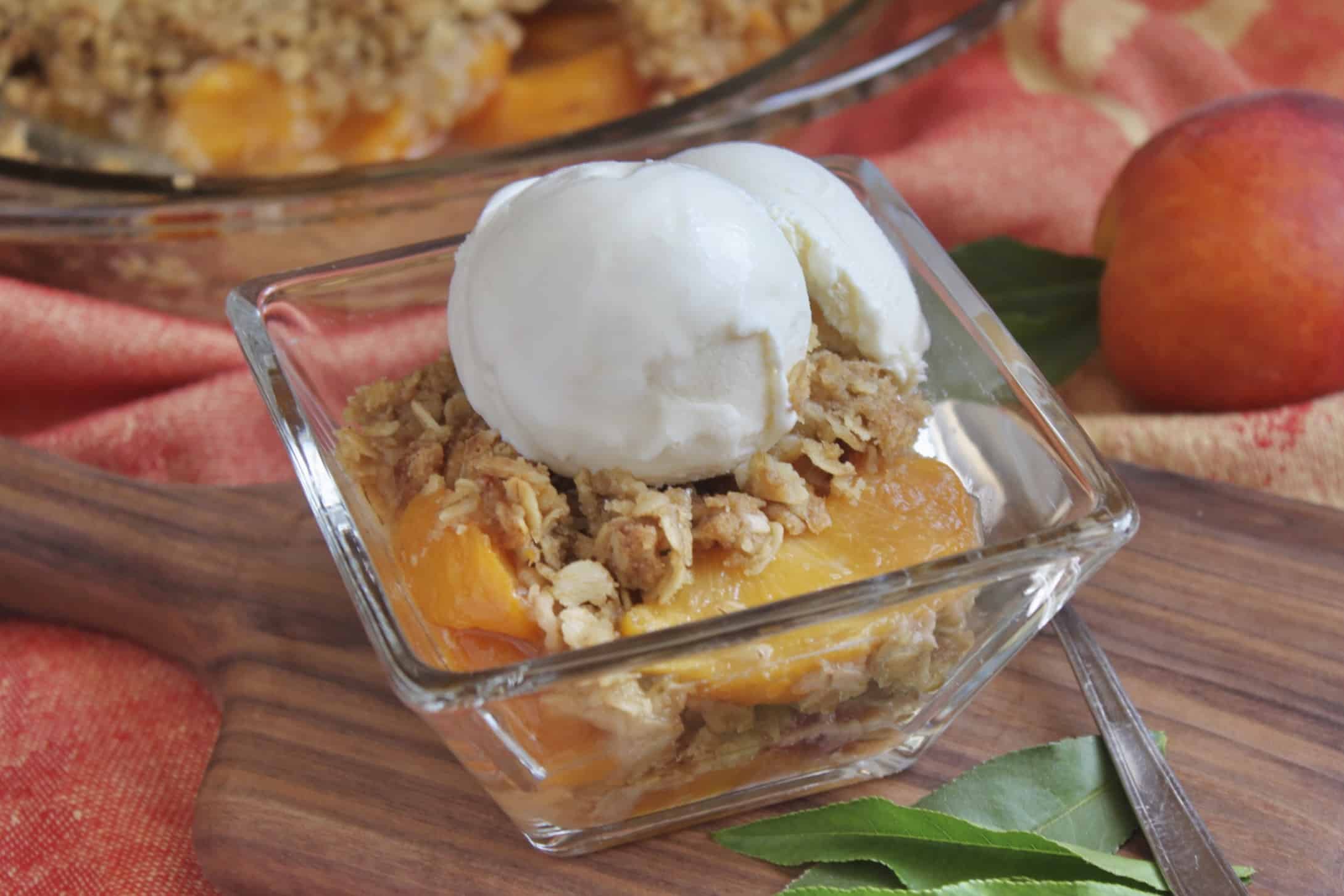 square glass bowl with peach dessert and ice cream