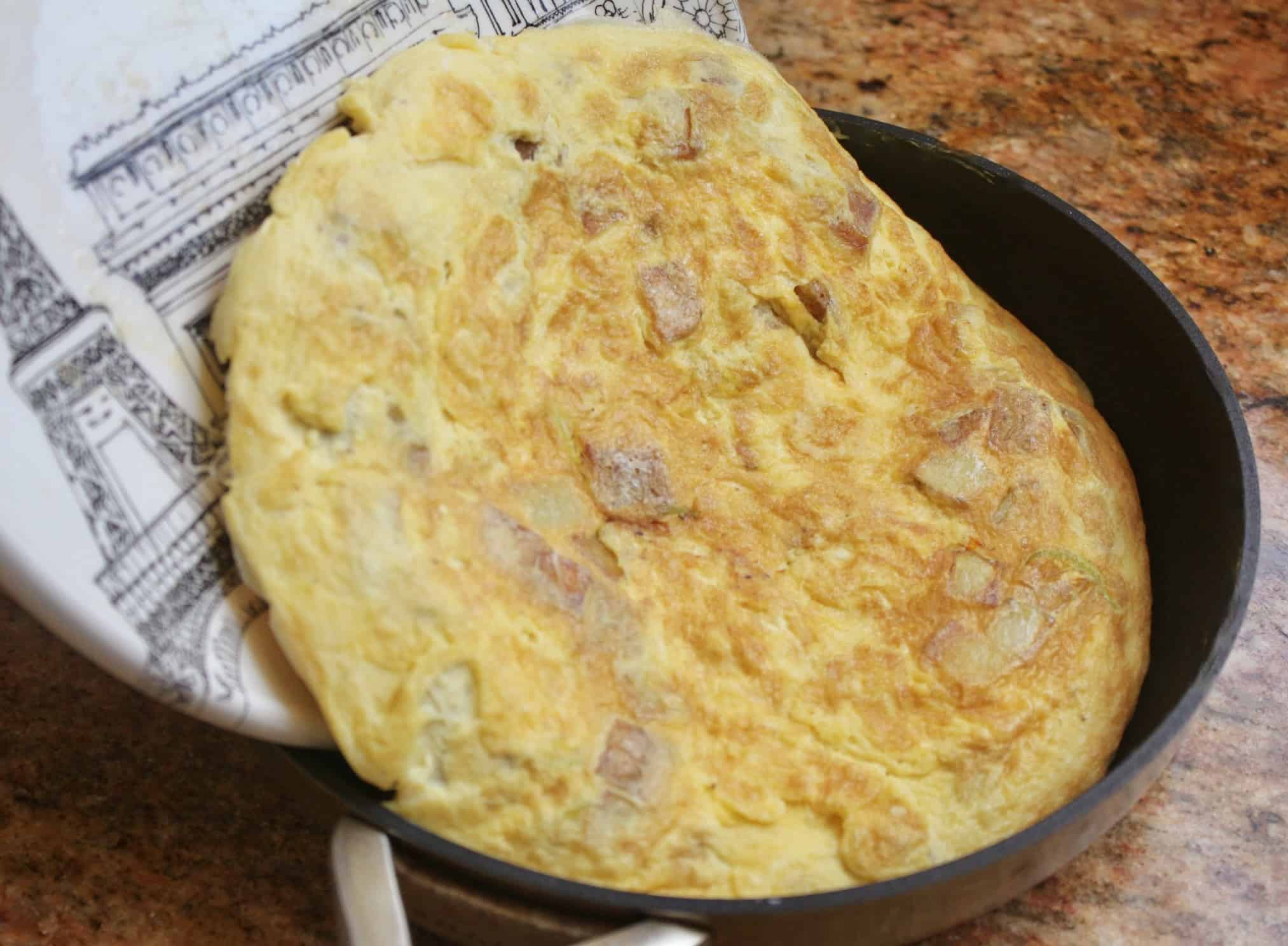 putting the frittata back into the pan.