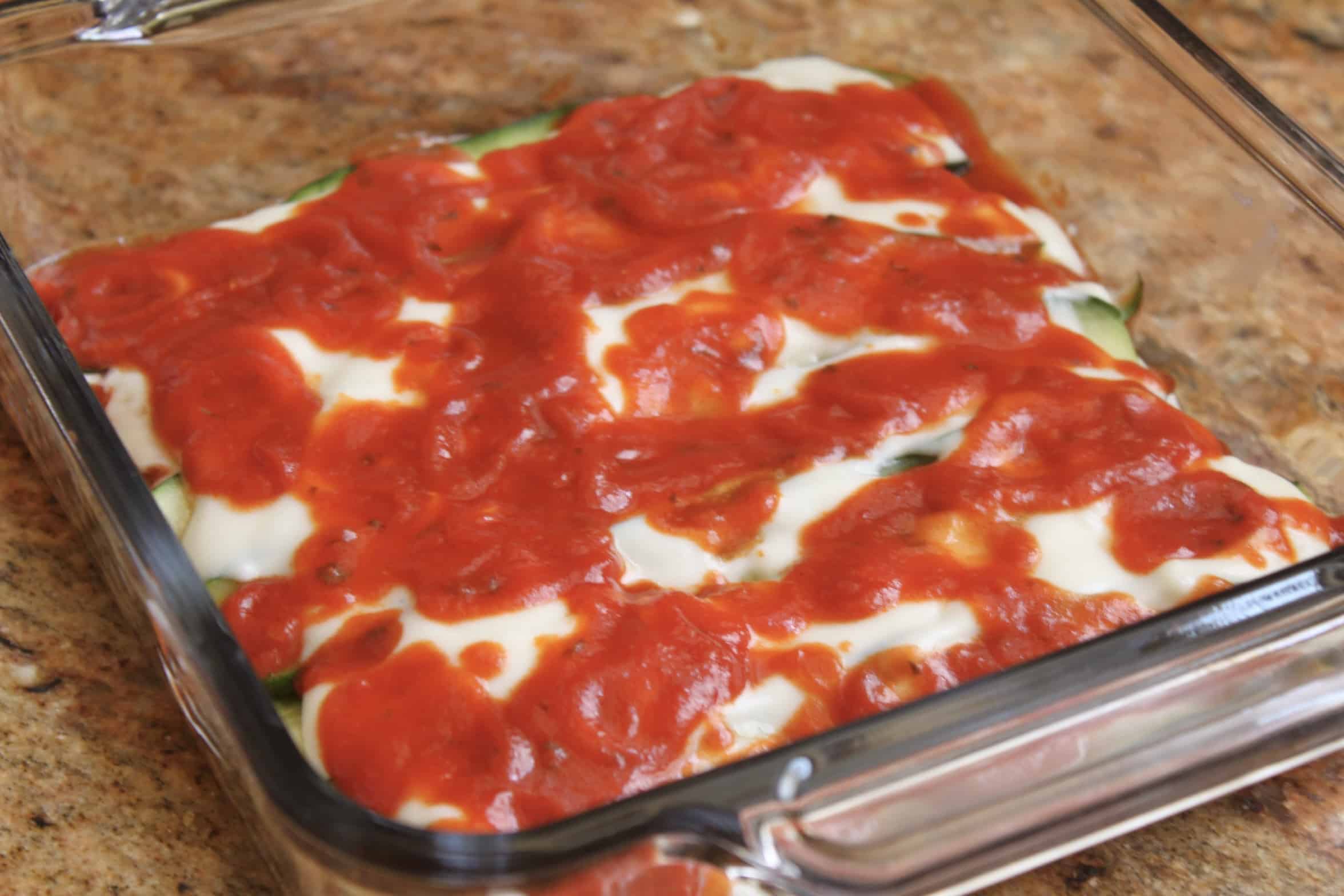 tomato sauce and white sauce layering on