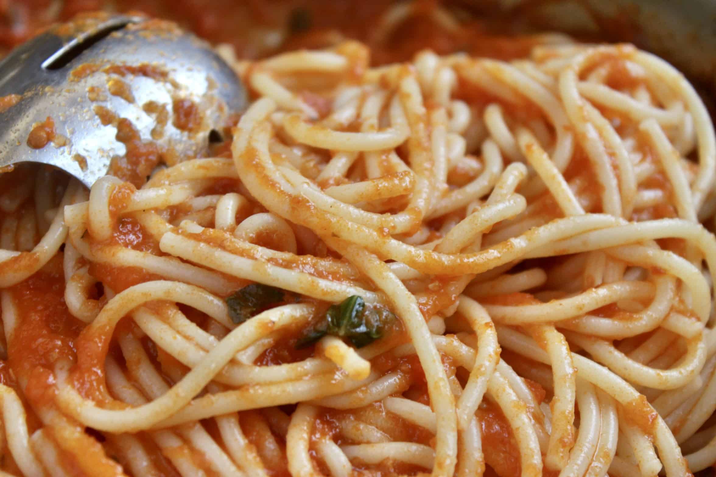 stirring pasta into the sauce