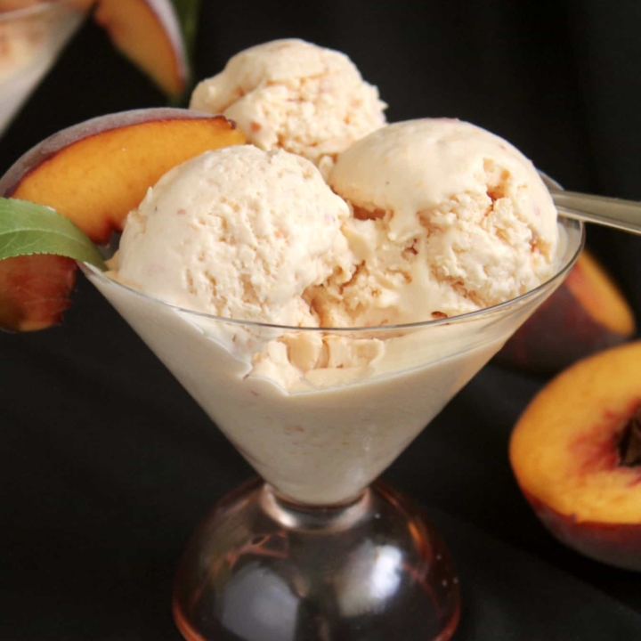 three scoops of peach ice cream in a glass