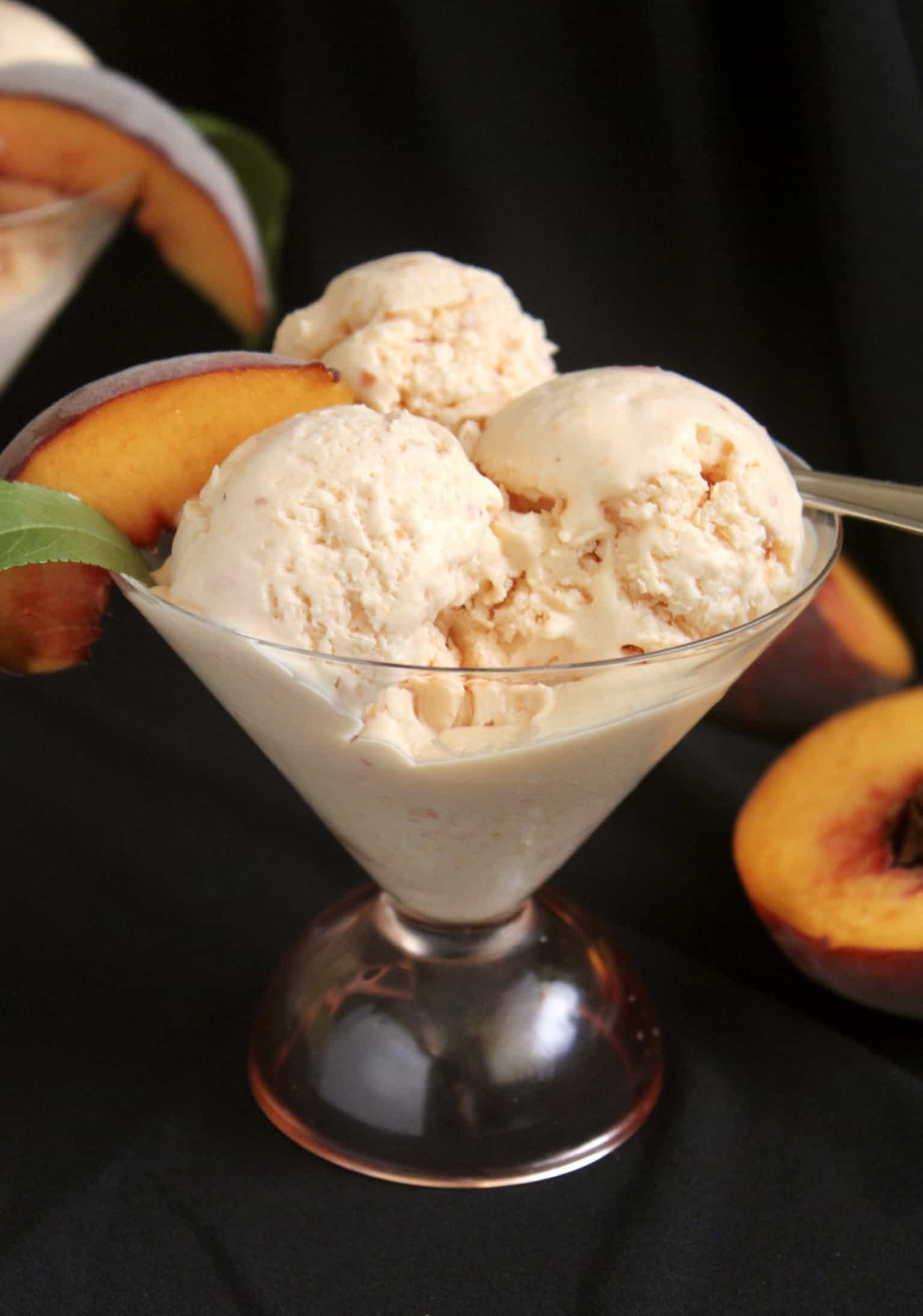 three scoops of peach ice cream in a glass