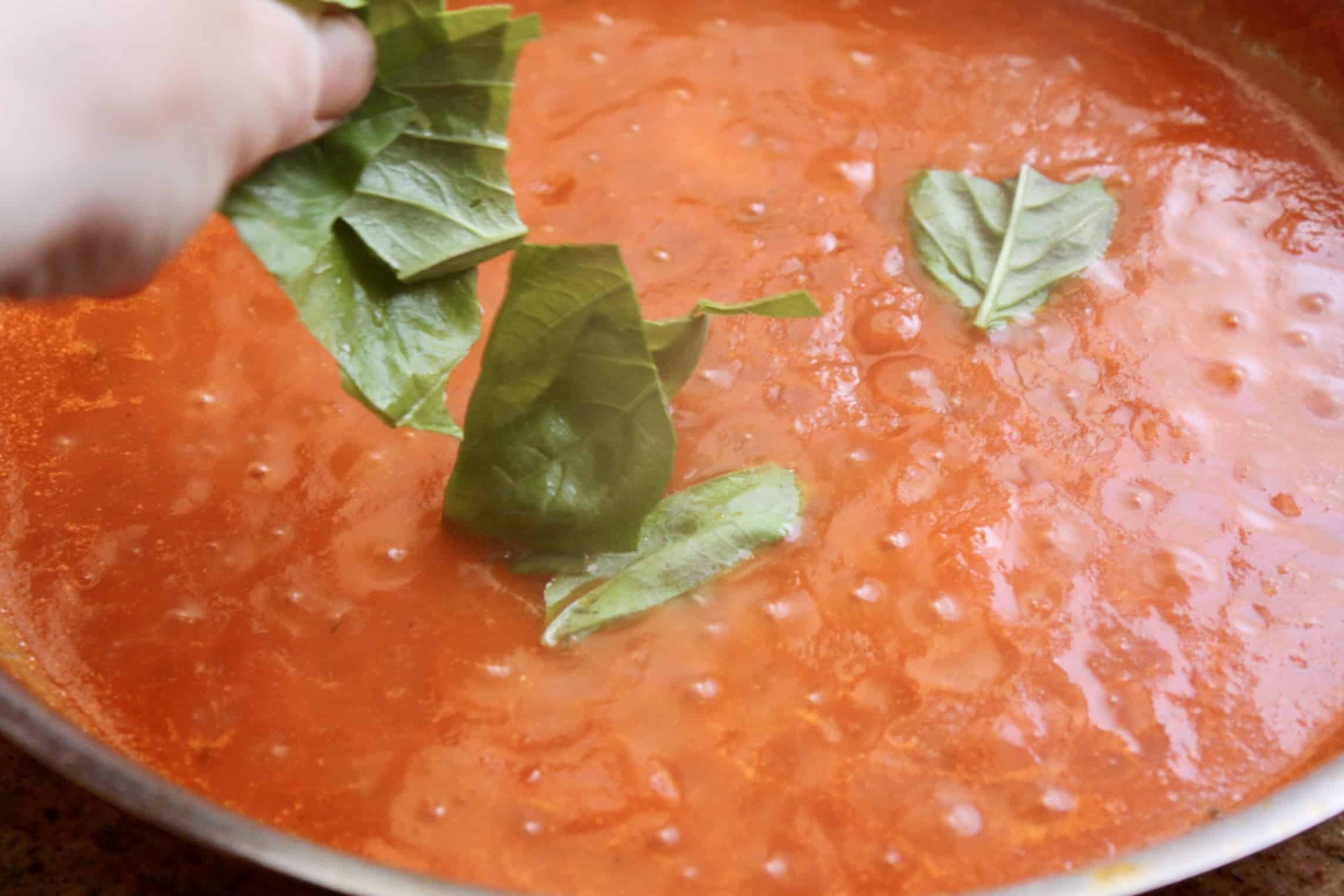 adding basil leaves