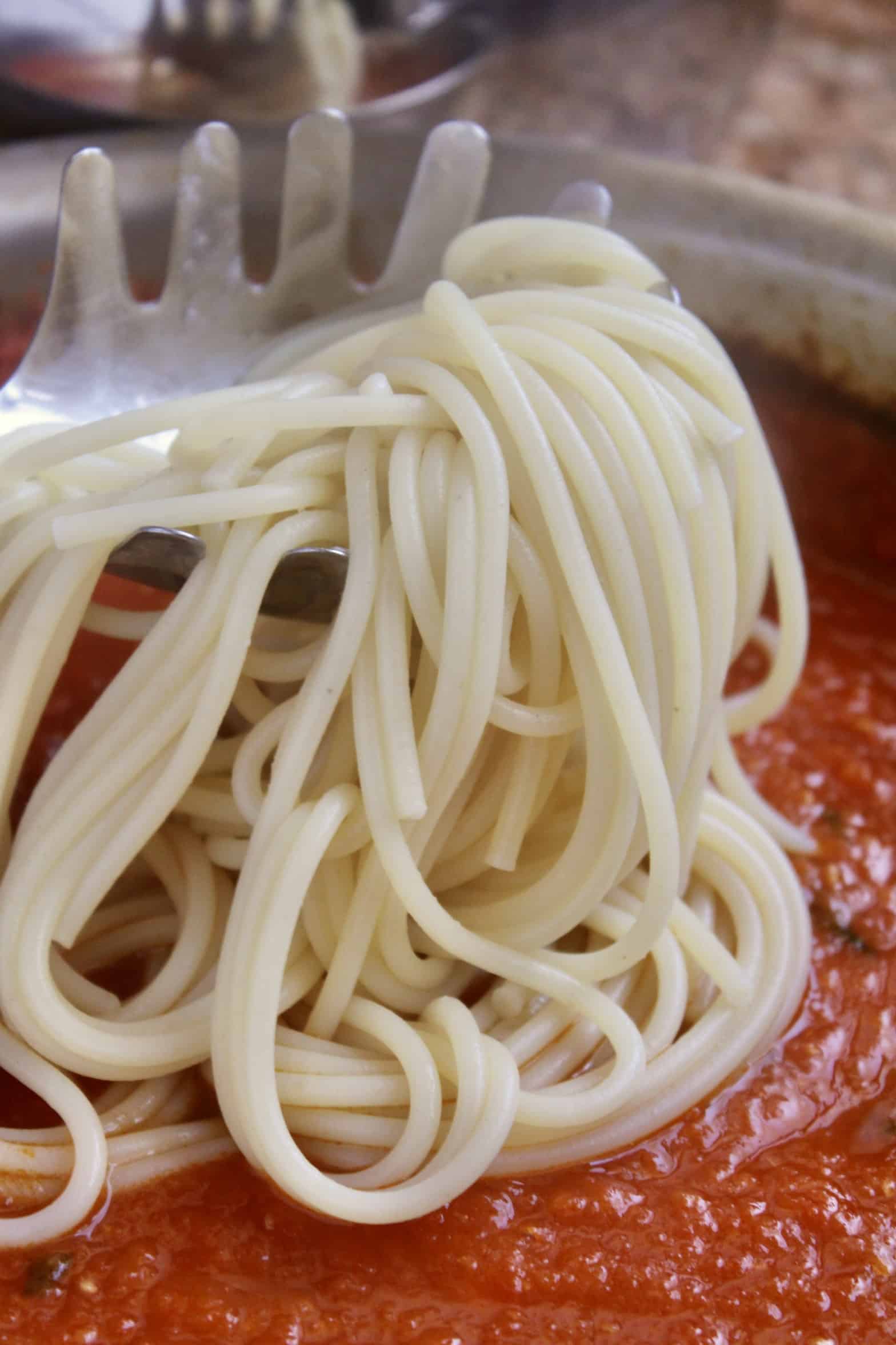 adding spaghetti to the fresh tomato sauce