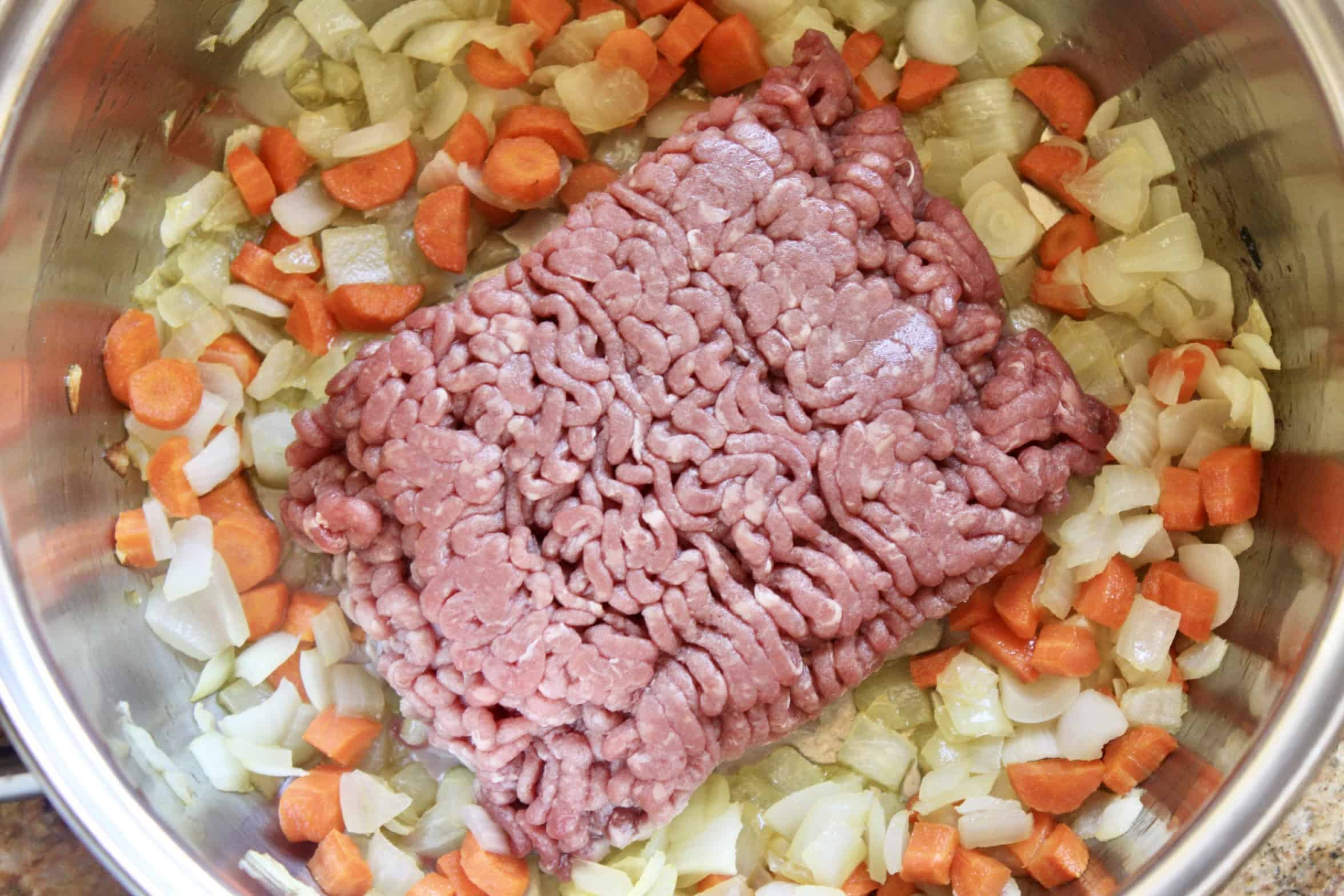 ground beef going into a pot 