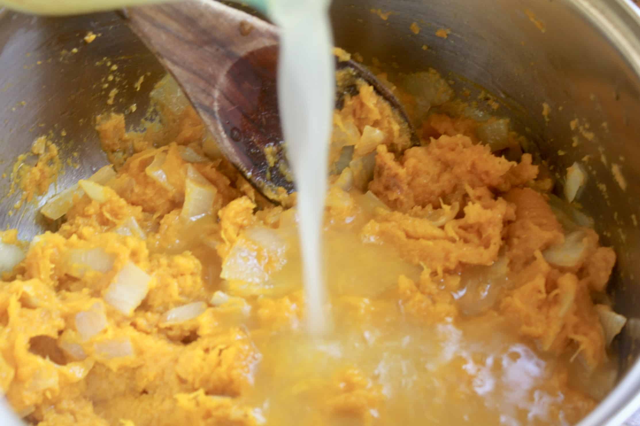 adding broth to the pot