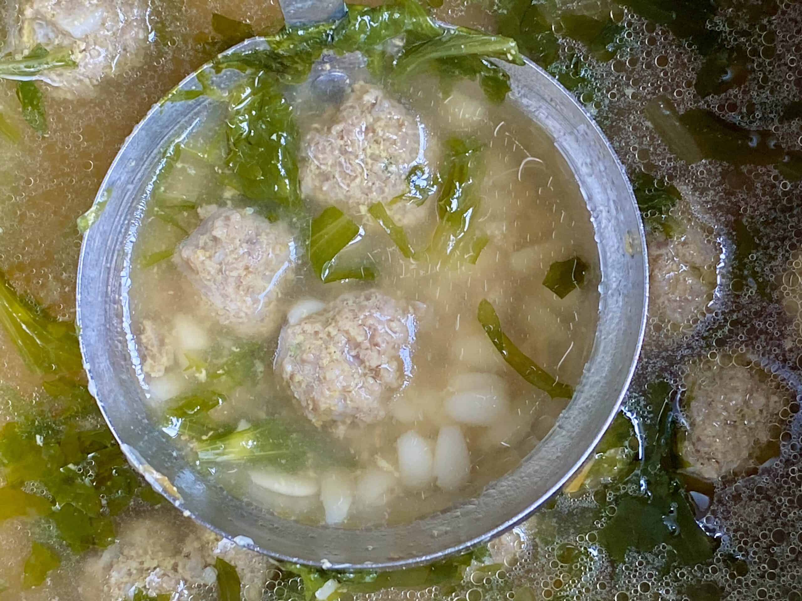 mini meatballs in a ladle of wedding soup