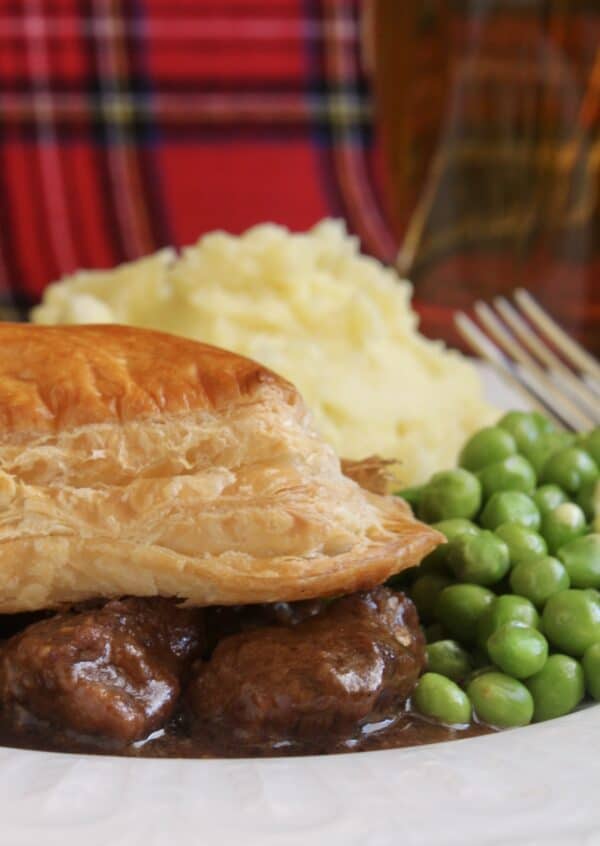 scottish steak pie, potatoes and peas with tartan background