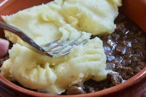 adding potatoes to the meat