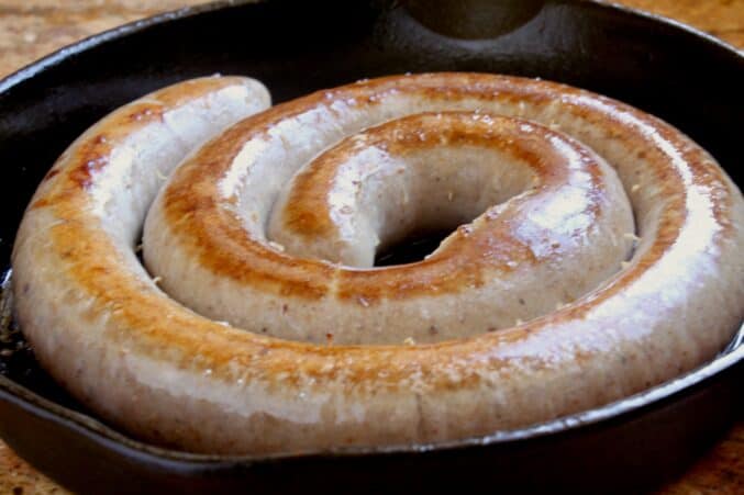 cooking the sausage link in a cast iron pan