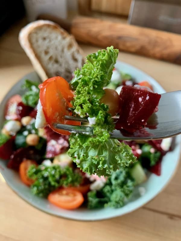 forkful of Kale Salad with Goat Cheese with slice of bread 