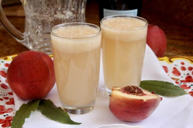 two Bellini drinks with white peaches