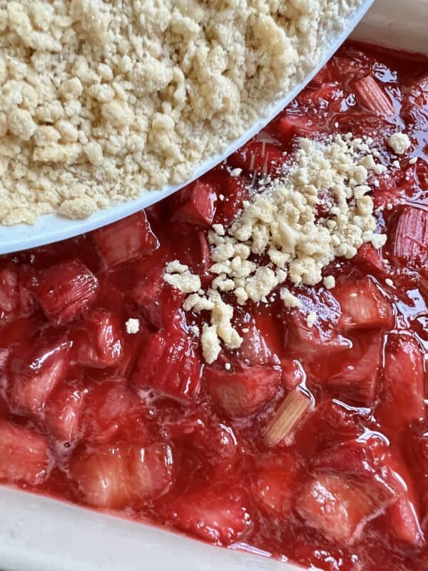 adding the crumble over the fruit filling