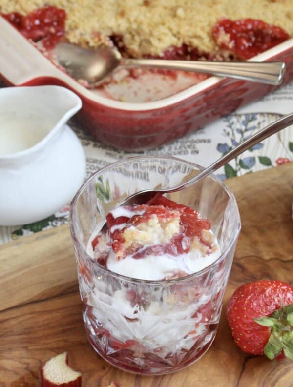 strawberry rhubarb crumble in a crystal glass with cream