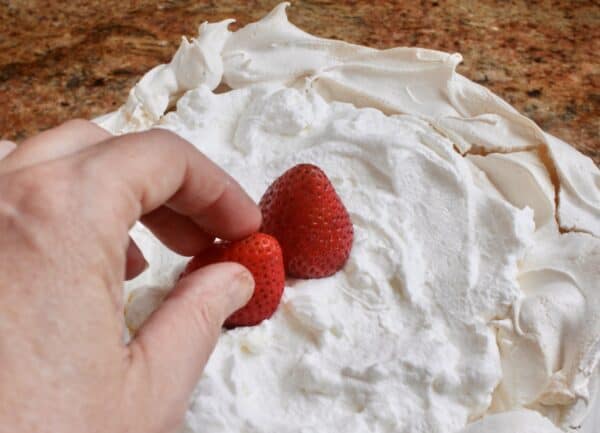 adding strawberries to the strawberry dessert