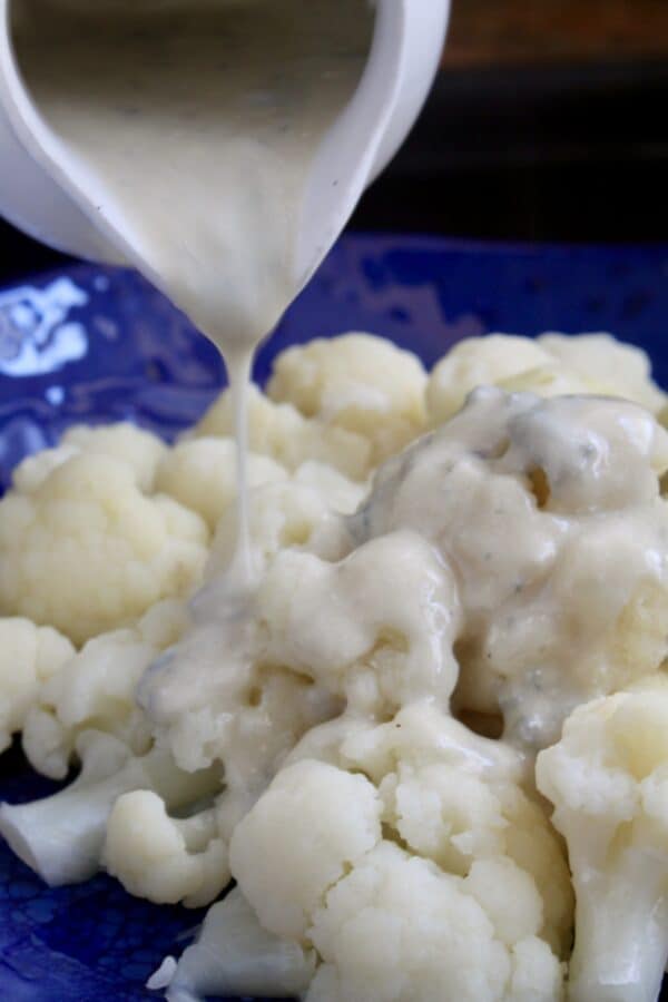 pouring Gorgonzola sauce over cauliflower