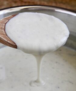 gorgonzola sauce pouring from a wooden spoon