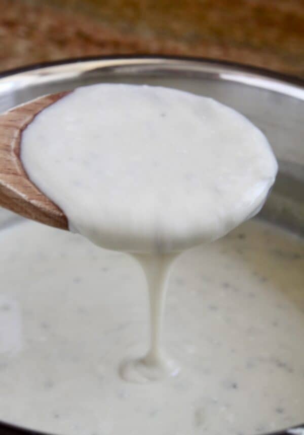 gorgonzola sauce pouring from a wooden spoon