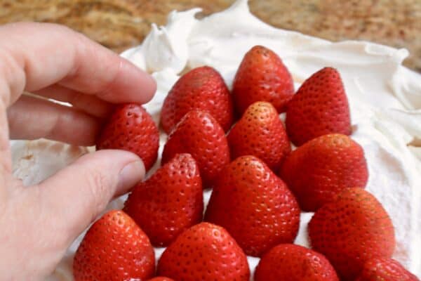 adding strawberries to the strawberry dessert