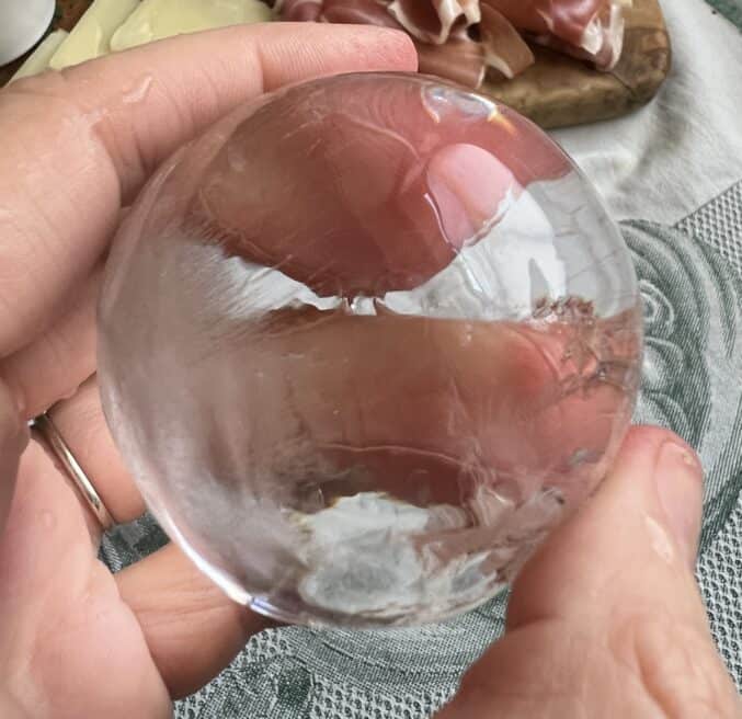 hand holding clear ice ball