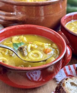 soup joumou in a spoon with red bowl