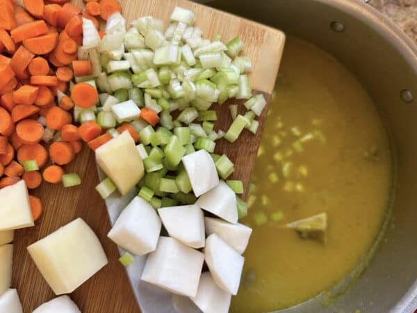 adding vegetables to soup