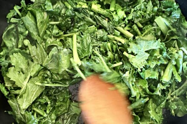 stirring rapini in pan