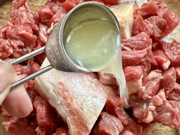 pouring lime juice onto beef and bones