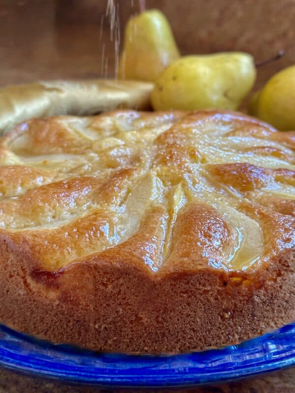 Honey pear cake getting sprinkled with sugar