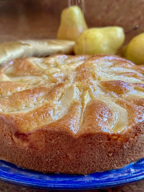Honey pear cake getting sprinkled with sugar