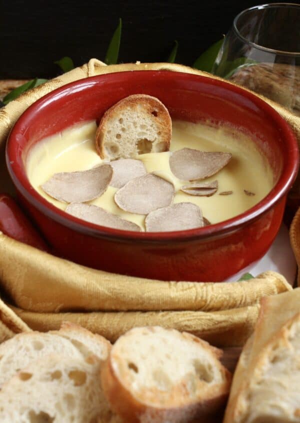 Truffle fondue with bread dipped in and shaved truffles on top