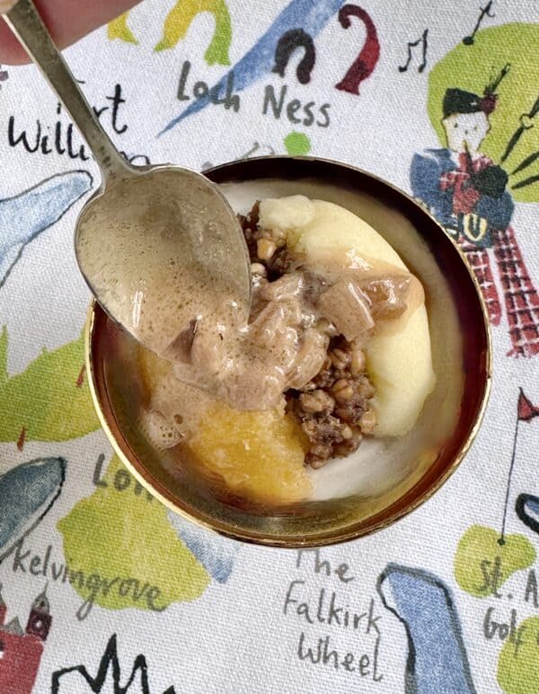 spooning whisky sauce over a mini serving of haggis, neeps and tatties