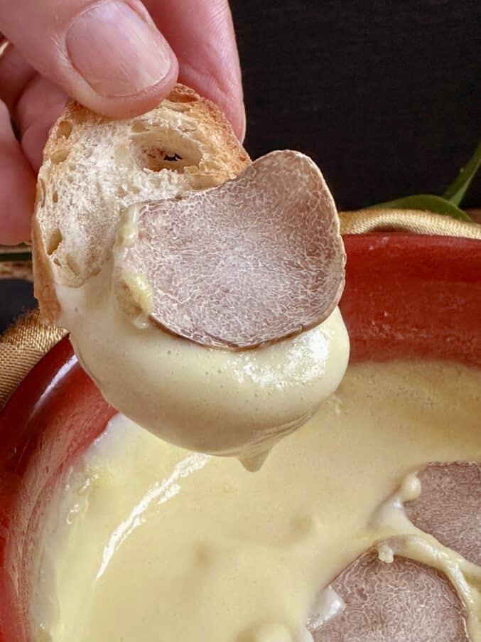 dipping bread into truffle fondue