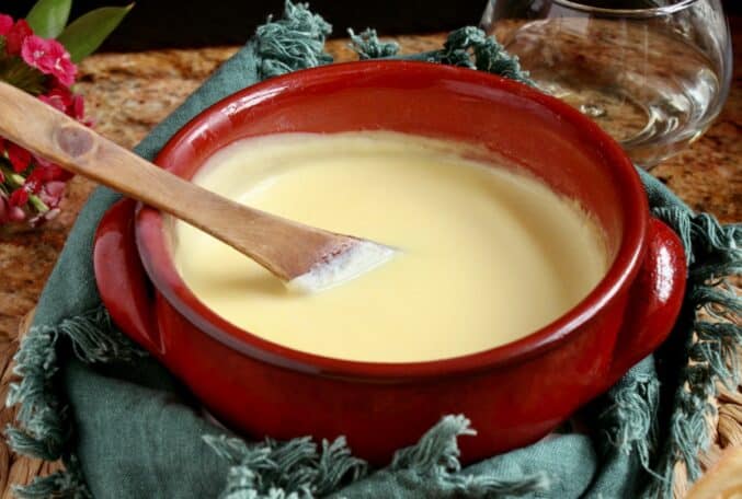 red bowl with fondue and wooden spoon